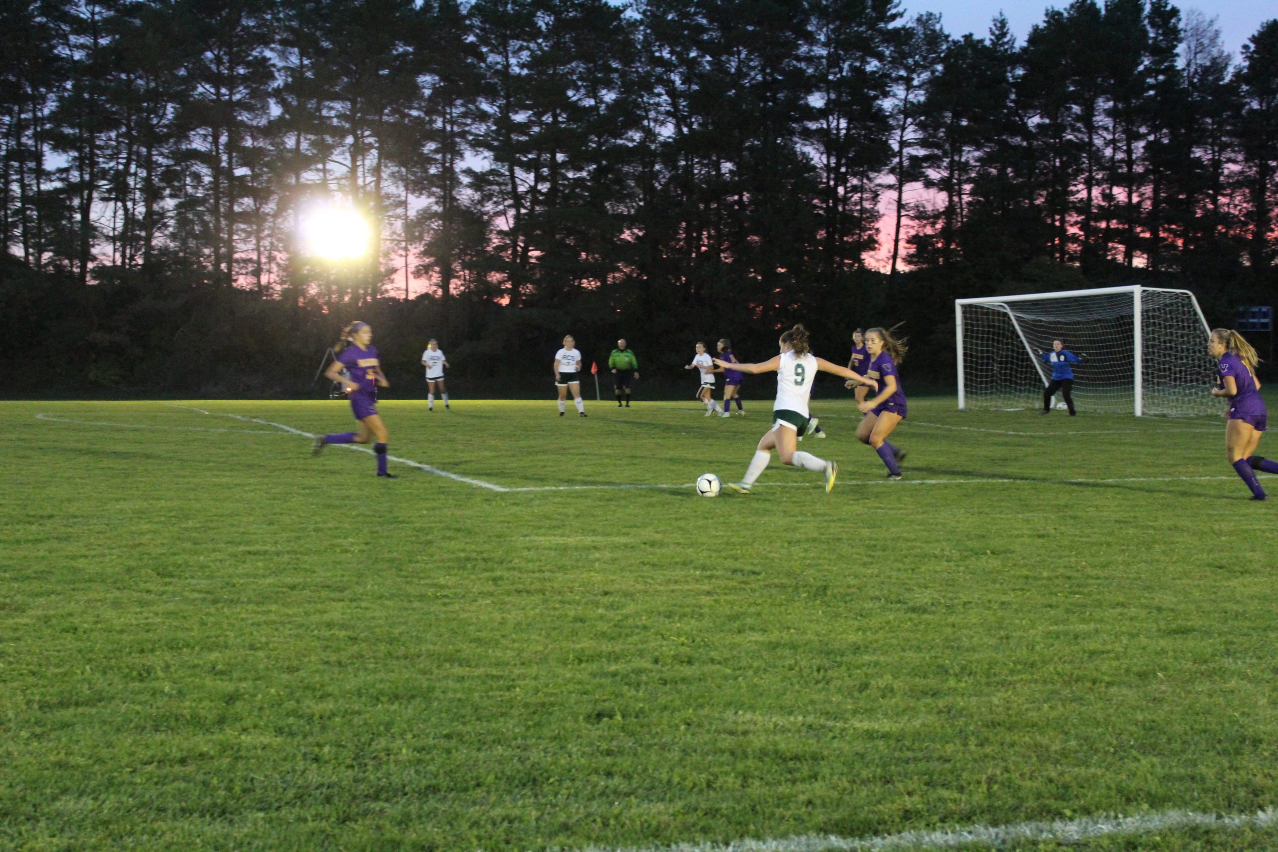 A photo of two highschoolers playing soccer