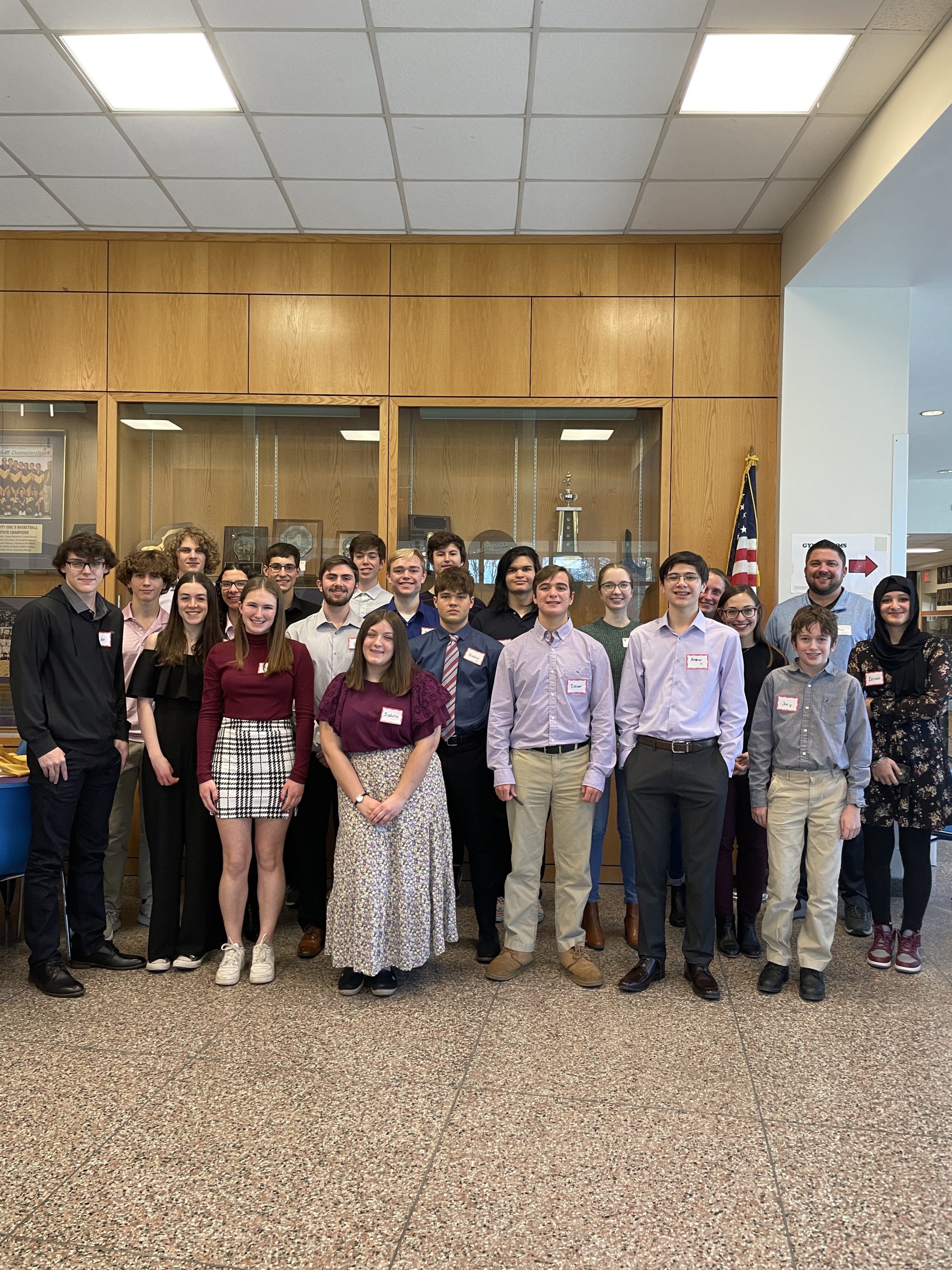 A group of students dressed in professional attire stand together at Voorheesville High School.