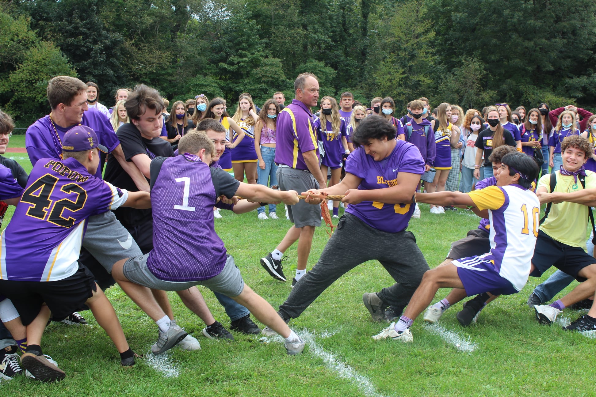 students playing tug of war with crowd watching