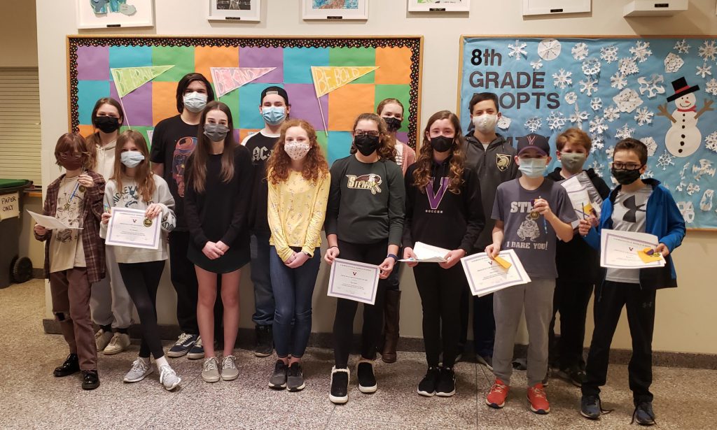 students standing in a jagged line holding certificates