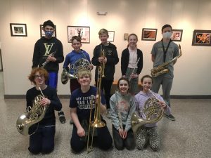 nine students holding their instruments and smiling for photo