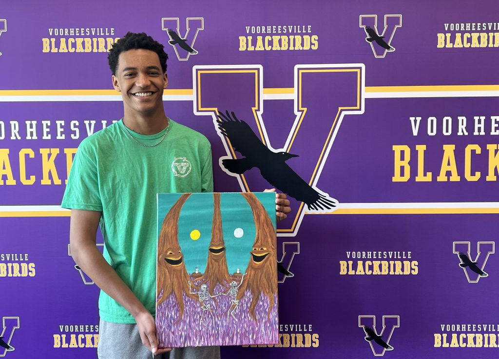 student holding a colorful painting