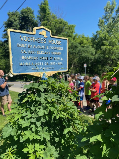 historic sign with trees and students in the background