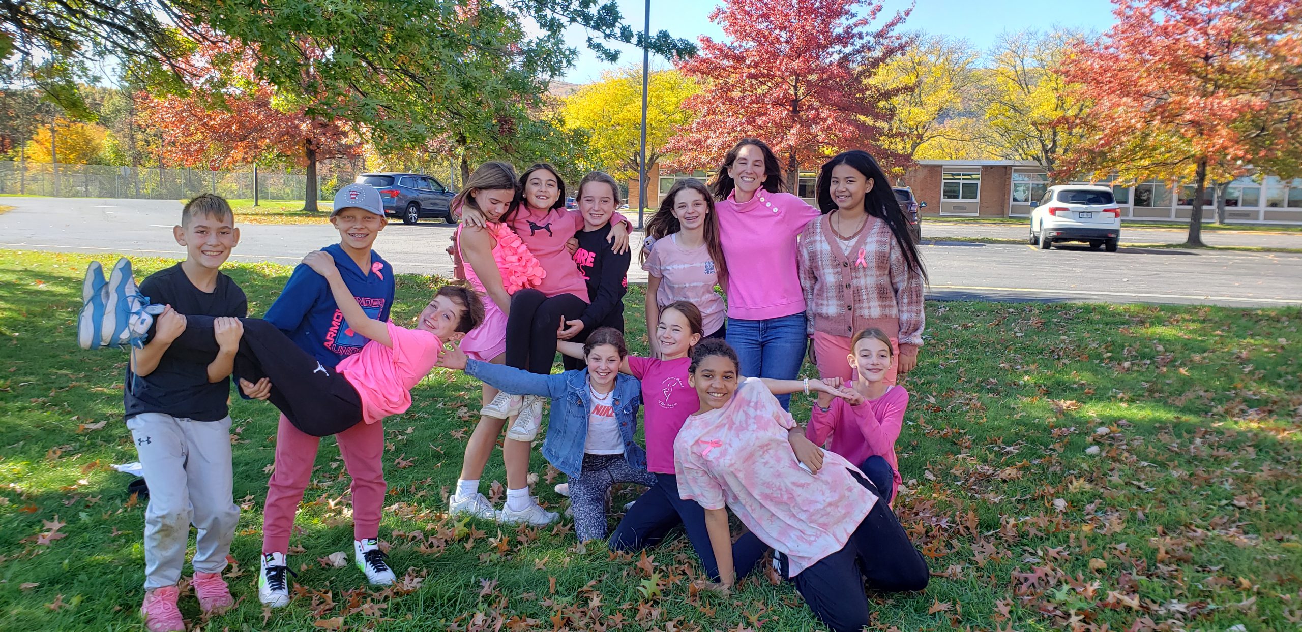 Middle school students dress in pink and pose for a photo to spread awareness for Breast Cancer