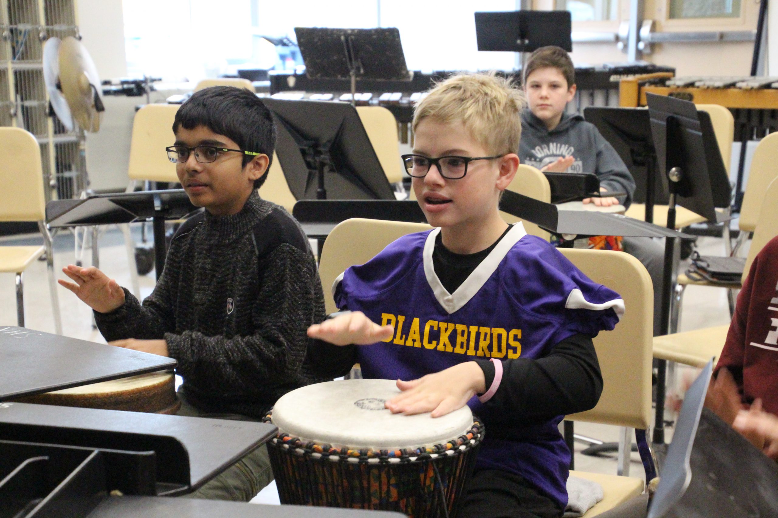 Elementary students play a bongo in class