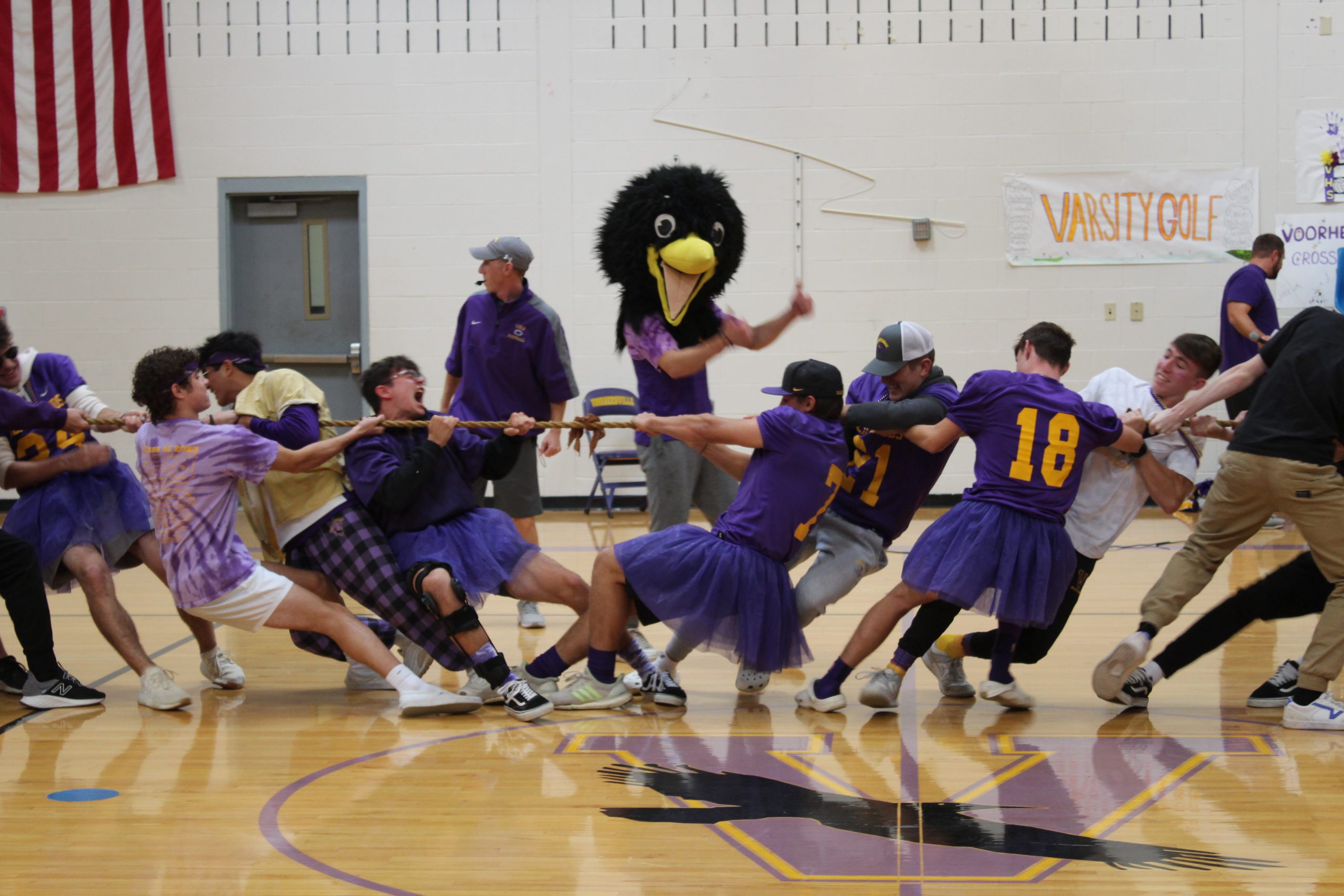 A photo of students engaging in a game of tug of war with the Voorheesville Blackbird mascot cheering them on