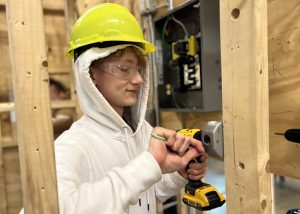 Voorheesville senior Shea dons a construction helmet and holds a drill