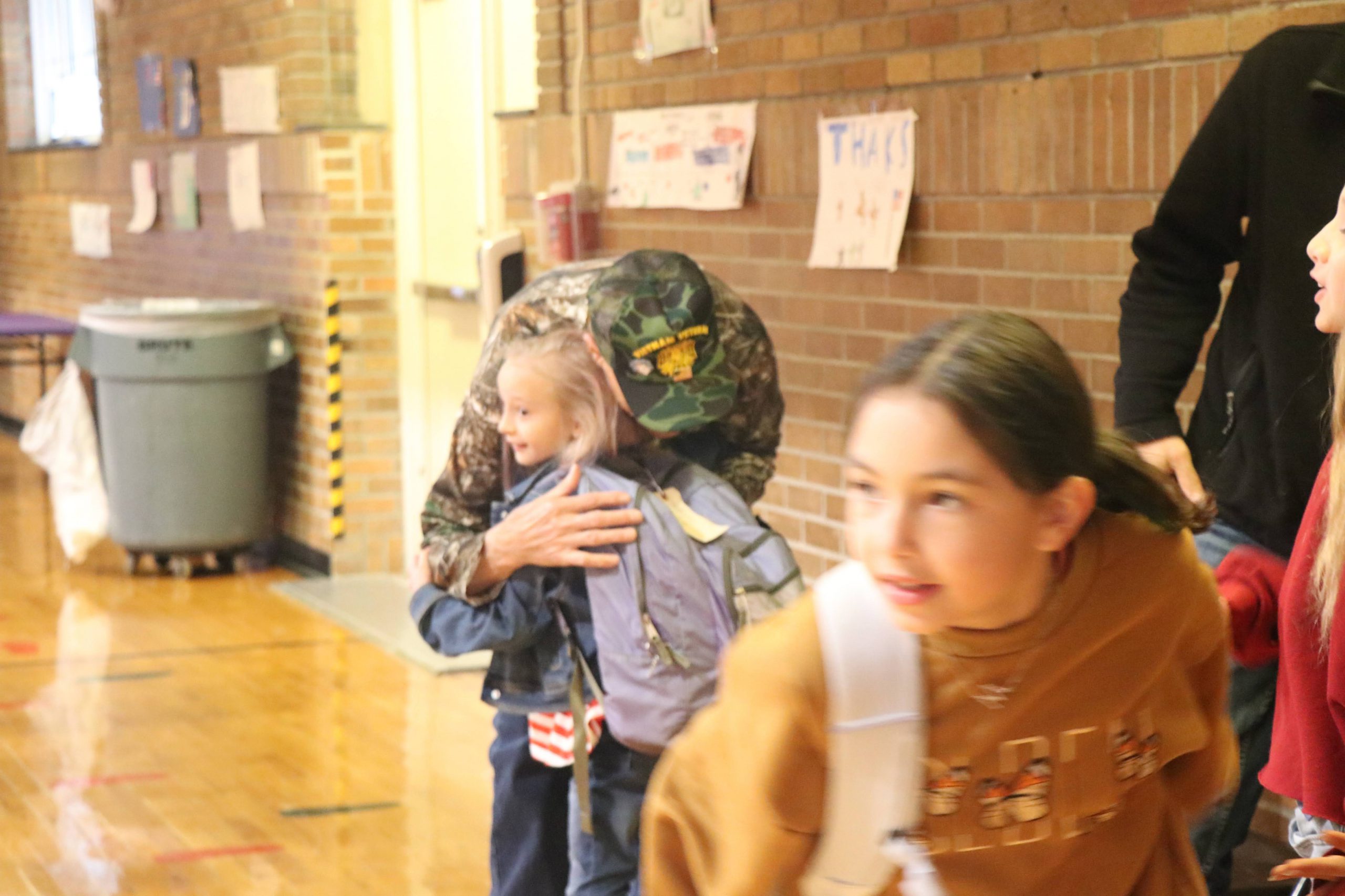 A photo of a VES student hugging her veteran grandfather at the VES Veterans Day Breakfast.