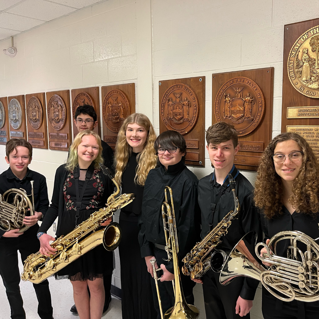 Members of the high school band stand with their instruments at music festival