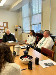 Commander Wood seated at table with Voorheesville Central School District staff.