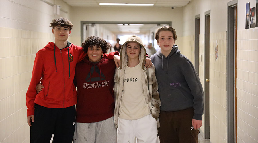 Four middle school boys in hall for slider