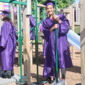 Student in cap and gown on playground