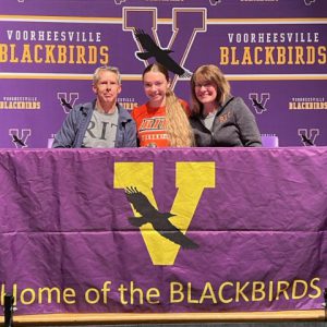 Three people sit at Home of the Blackbirds table for signing day
