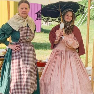 Woman and teen dressed in Civil War era clothing.
