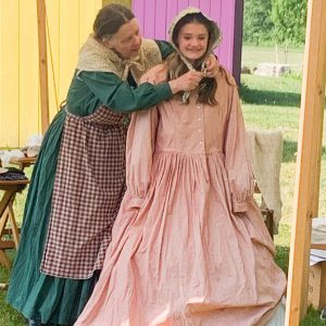 Woman and teen dressed in Civil War era clothing.