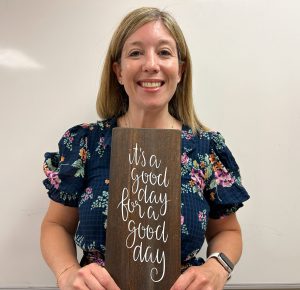 Brianna Olsen holds sign that says "It's a good day to have a good day."