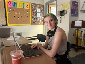 Student sits at table with a laptop
