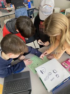 Students work together to solve math problems during escape room classroom exercise.