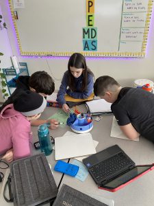 Students work together to solve math problems during escape room classroom exercise.