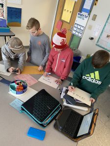 Students work together to solve math problems during escape room classroom exercise.