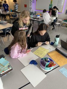 Students work together to solve math problems during escape room classroom exercise.