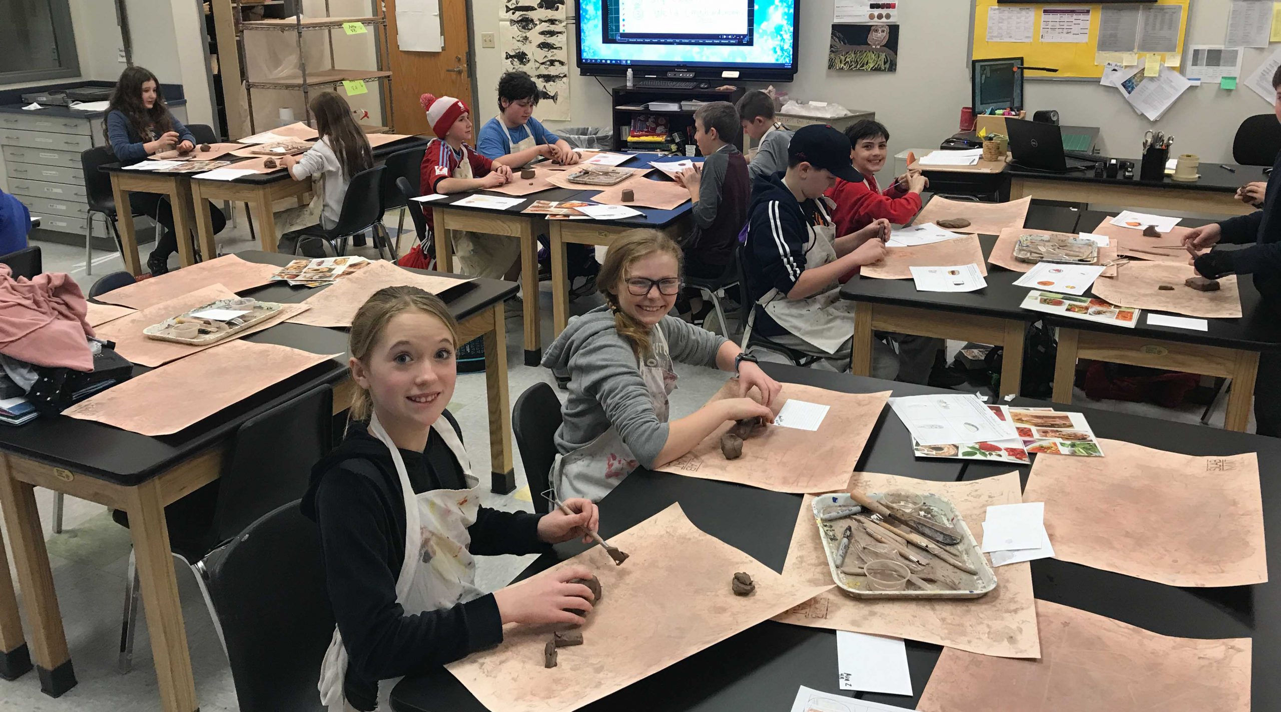 Students working with clay on tables.