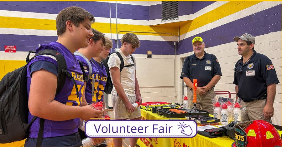 Students, some wearing blackbird jerseys, talk with members of the New Salem Fire Department at Volunteer Fair.