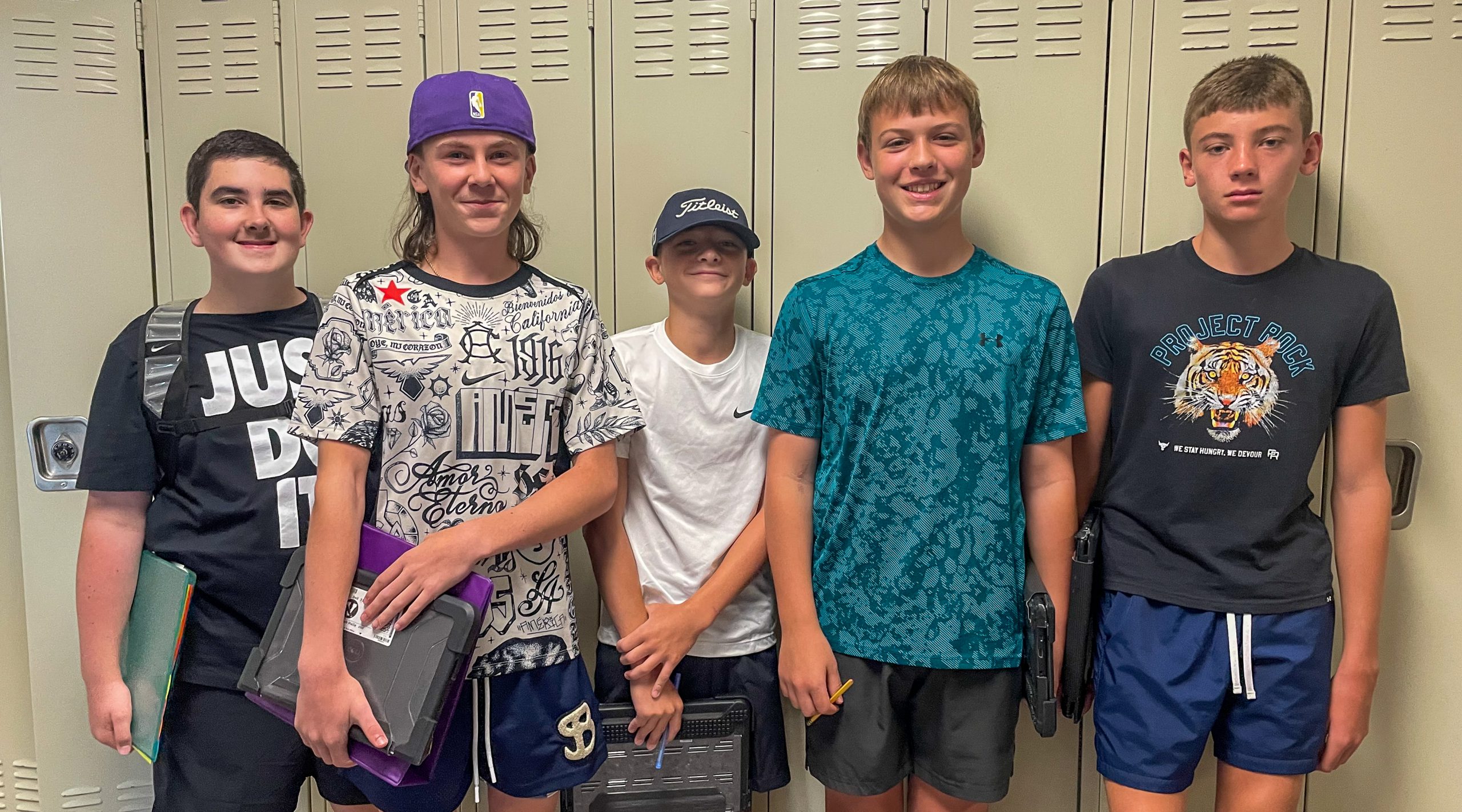 Five middle school students stand in front of locker.