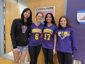 Four teens, each wearing Voorheesville branded shirts, stand together.