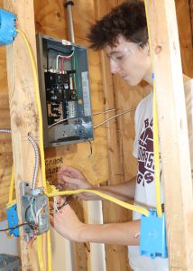 Teen works with electrical wiring.