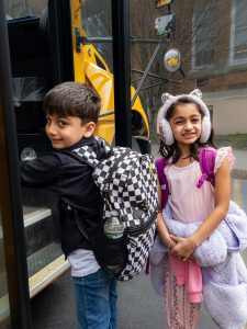 Two children get ready to board a school bus.